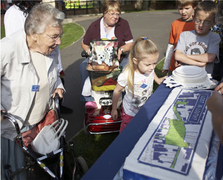 residents looking at decorated cake and reading comments from the event